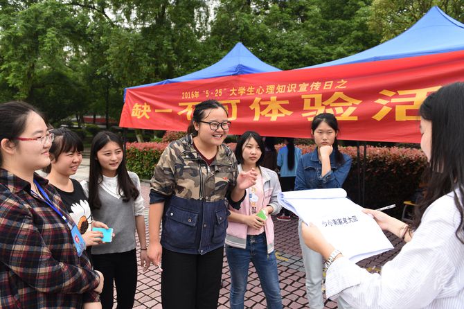 图为马克思主义学院大三学生正在参与看嘴型猜诗词“缺一不可”残疾体验活动。